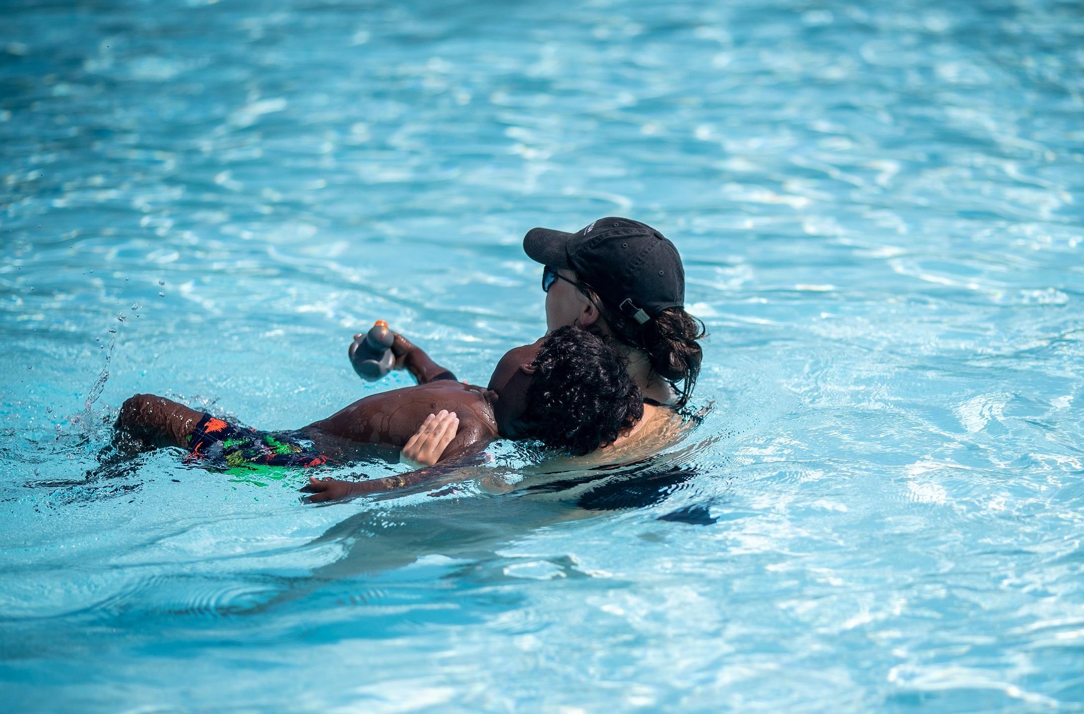 swim instructor teaching child to float on back