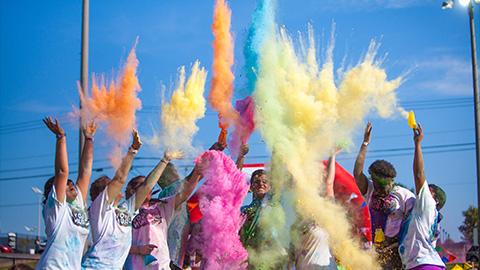 学生们在色彩赛跑中向空中投掷颜色